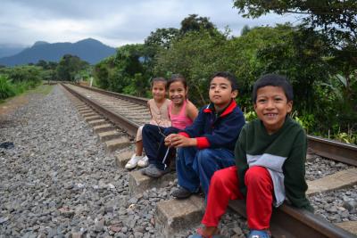Un grupo de niños sentados en las vías.