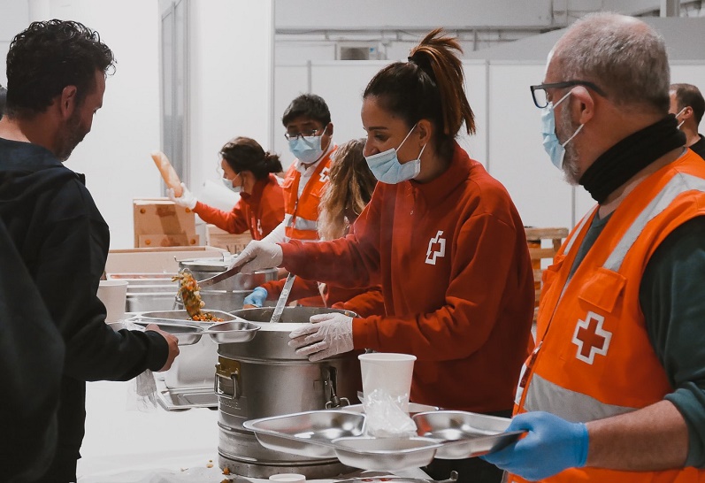 Voluntarios de Cruz Roja Española sirviendo comidas.