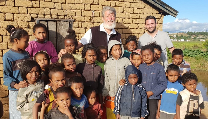 El padre Pedro Opeka y Gastón Vigo junto a un grupo de niños de Akamasoa