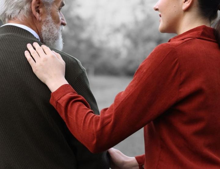 Una cuidadora acompaña a una persona mayor en su rutina diaria, reflejando el valor del apoyo humano.